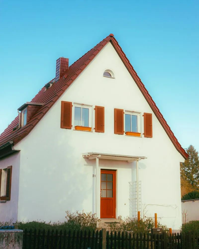 Einfamilienhaus mit rotem Dach und roter Haustür